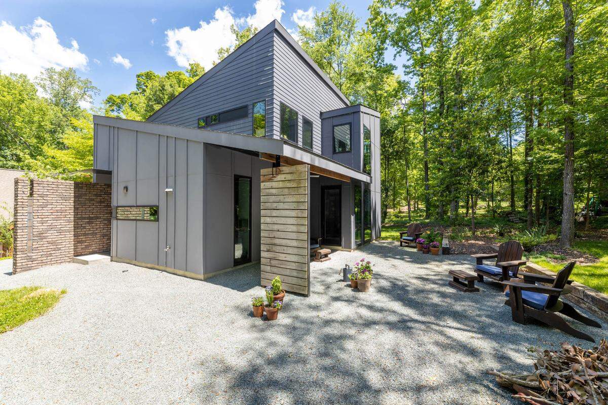 Toby Witte’s modern home outside of the kitchen and living room is a patio area with some Adirondack chairs and plants.
