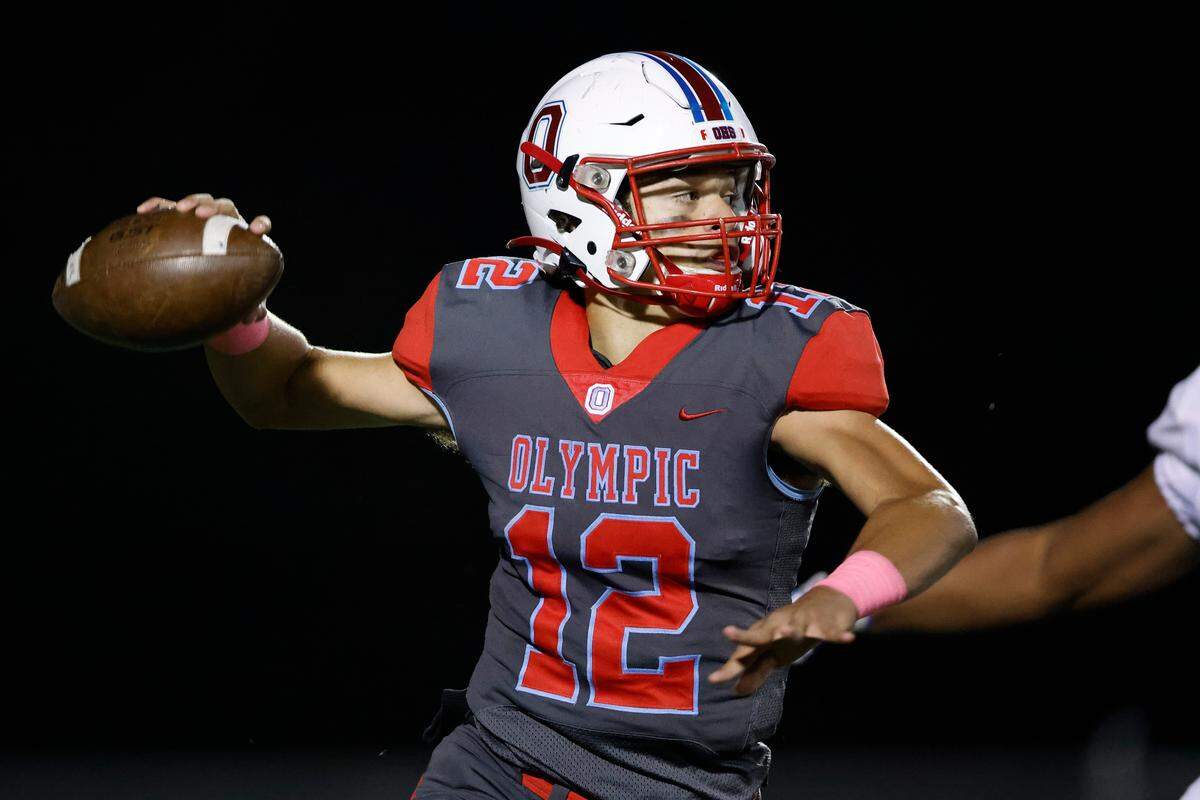 Olympic’s Elijah Holmes (12) passes the ball during a game against Ardrey Kell at Olympic High School in Charlotte, N.C., Friday, Oct. 21, 2022.