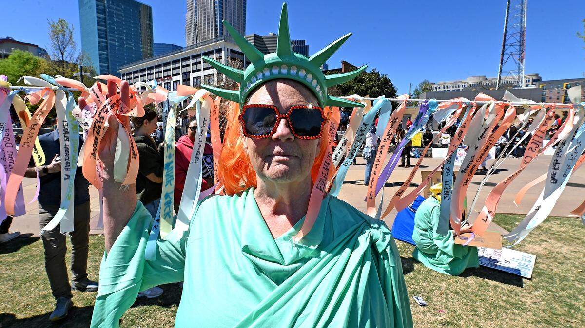 The Lady Liberty stands in front of a strand of message covered ribbons in First Ward Park during a No Kings rally in Charlotte, NC on Saturday, March 28, 2026.