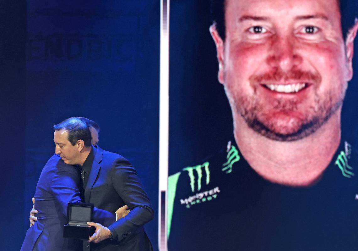 Former NASCAR driver Kurt Busch, left, is hugged by his brother and NASCAR driver Kyle Busch, right, at the NASCAR Hall of Fame Induction Ceremony at the Charlotte Convention Center in Charlotte, NC on Friday, January 23, 2026. 