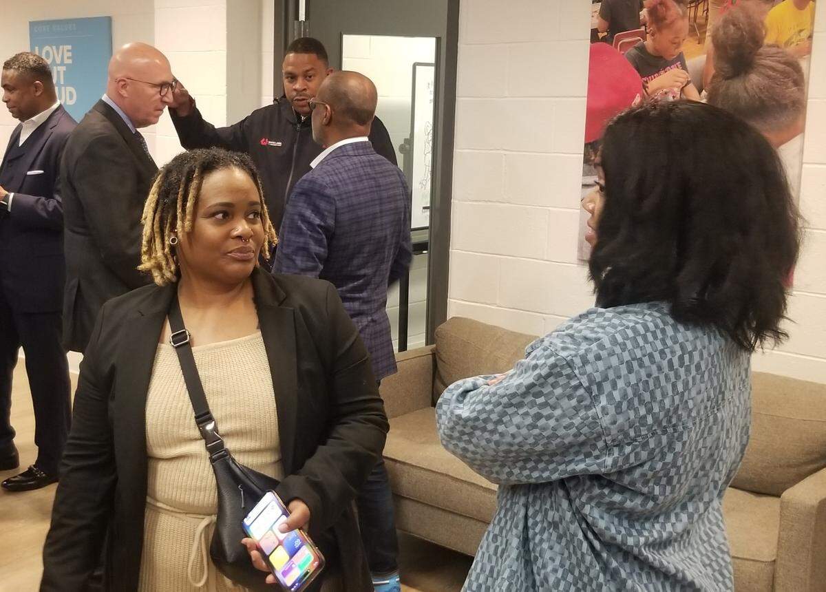 Jorikeka Downey, left, speaks to people about being an entrepreneur during an announcement for a new $40 million fund to help small business owners.