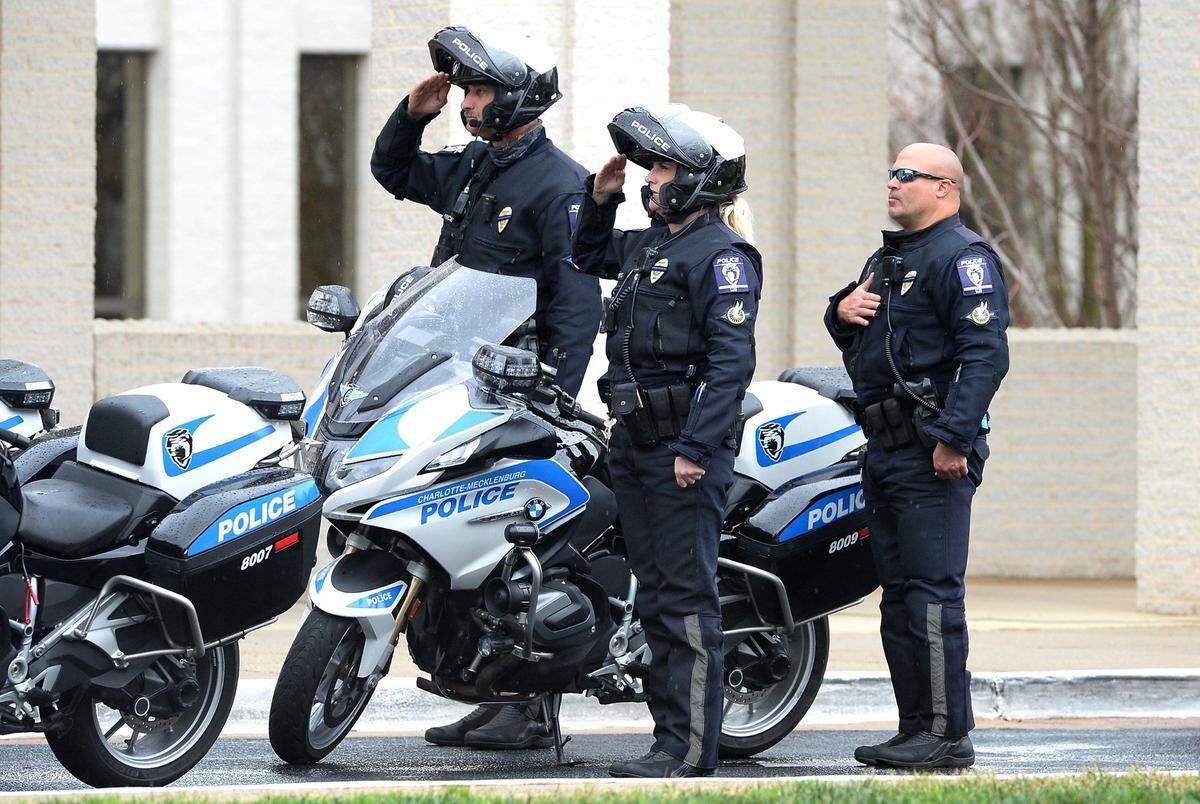 Charlotte-Mecklenburg motorcycle officers salute during the funeral service for CMPD officer Mia Goodwin at First Baptist Church in Charlotte, NC on Wednesday, December 29, 2021. Officer Goodwin who was killed while responding to a crash on Interstate 85 on December 22, 2021.