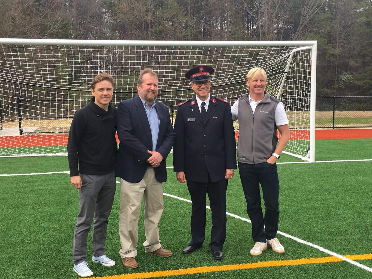 Dustin Swinehart (far right) at a Charlotte FC event unveiling a new soccer pitch in East Charlotte.