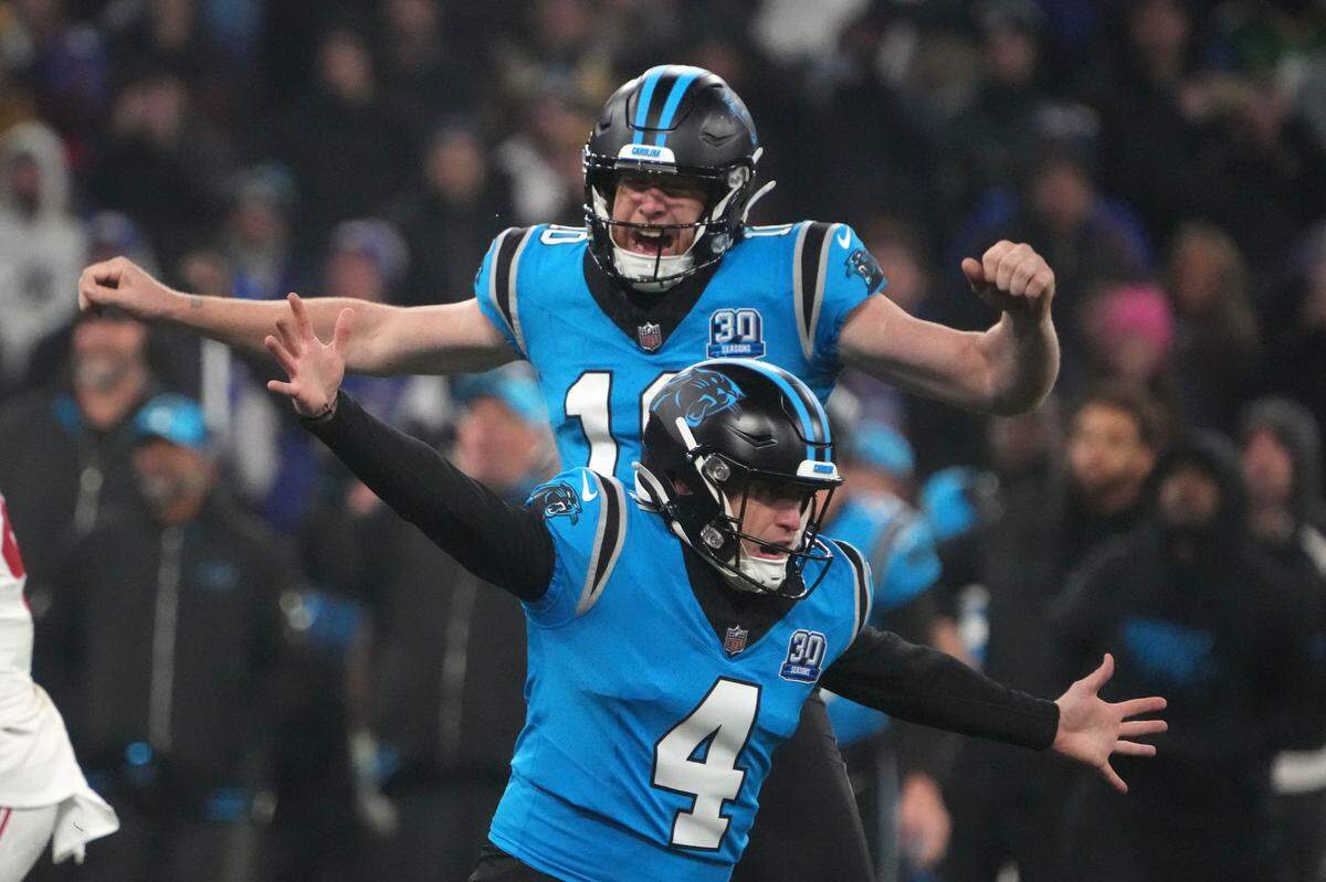 Carolina Panthers kicker Eddy Pineiro (4) celebrates with punter Johnny Hekker (10) after making a 36-yard field goal in overtime against the New York Giants during Sunday’s 2024 NFL Munich Game at Allianz Arena. The kick won the game for Carolina, 20-17.
