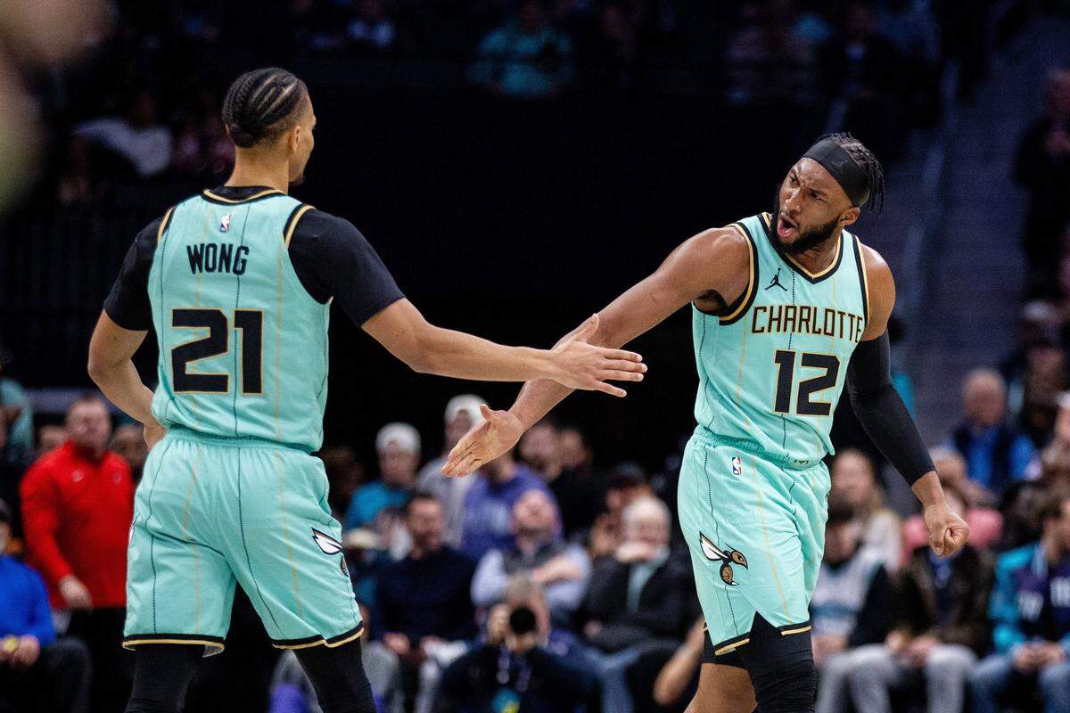 Charlotte Hornets forward Josh Okogie (12) celebrates with guard Isaiah Wong (21) during the second quarter against the Portland Trail Blazers at Spectrum Center.