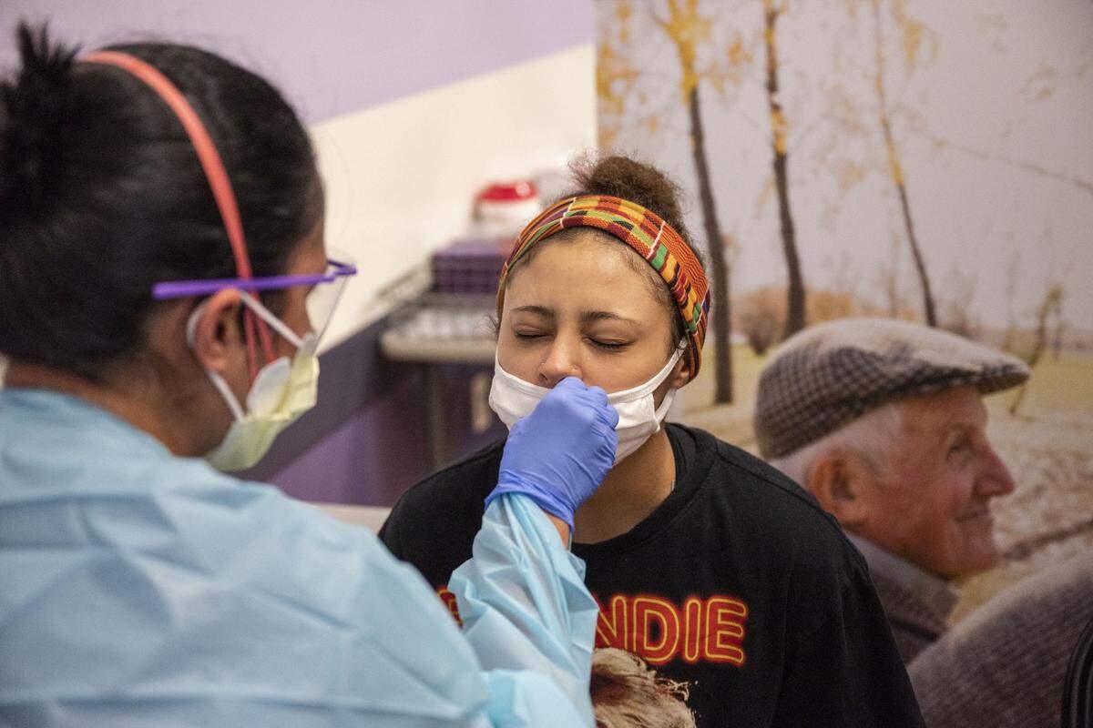 Alyssa Baker, right, winces a little as a Novant Health employee swabs her nose for COVID-19 at the health care provider’s Independence Boulevard location on Wednesday, September 8, 2021 in Charlotte, NC. State health officials are encouraging residents to get COVID vaccines before traveling this week for the Christmas holiday.