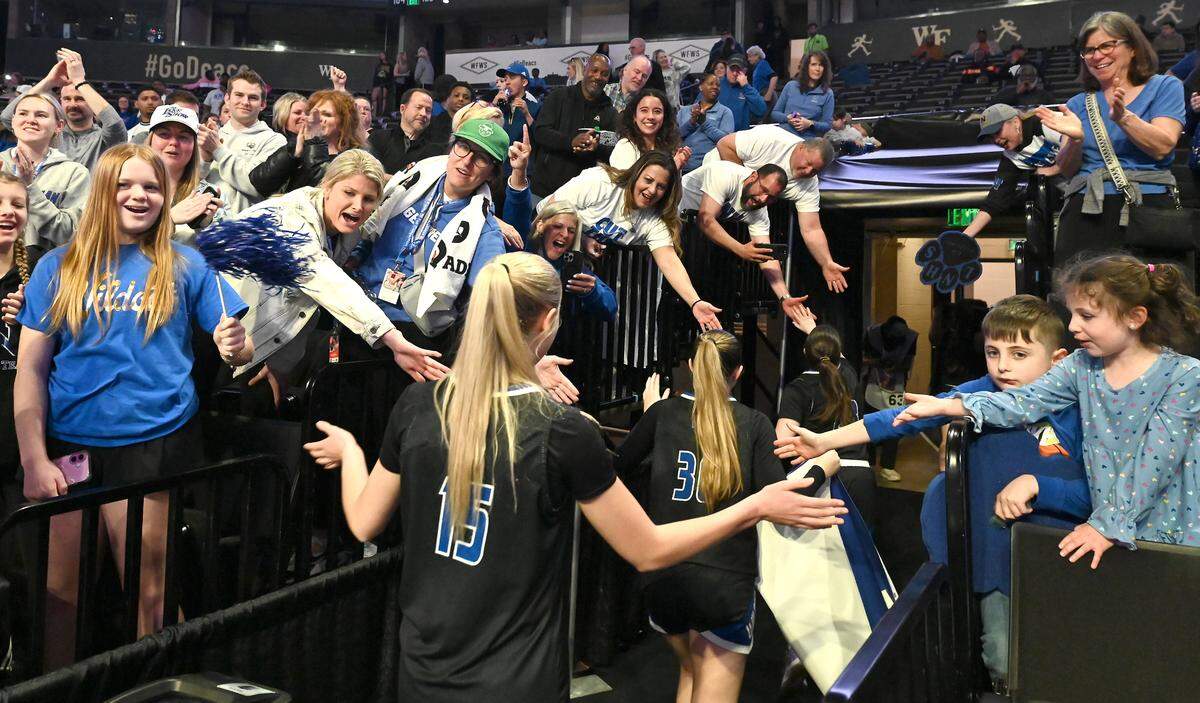 Lake Norman girls basketball fans reach out from the stands to congratulated the team on their 43-41 victory over Wakefield in the girls NCHSAA 4A State Championship game on Saturday, March 15, 2025 at Lawrence Joel Veterans Memorial Coliseum in Winston-Salem, NC.