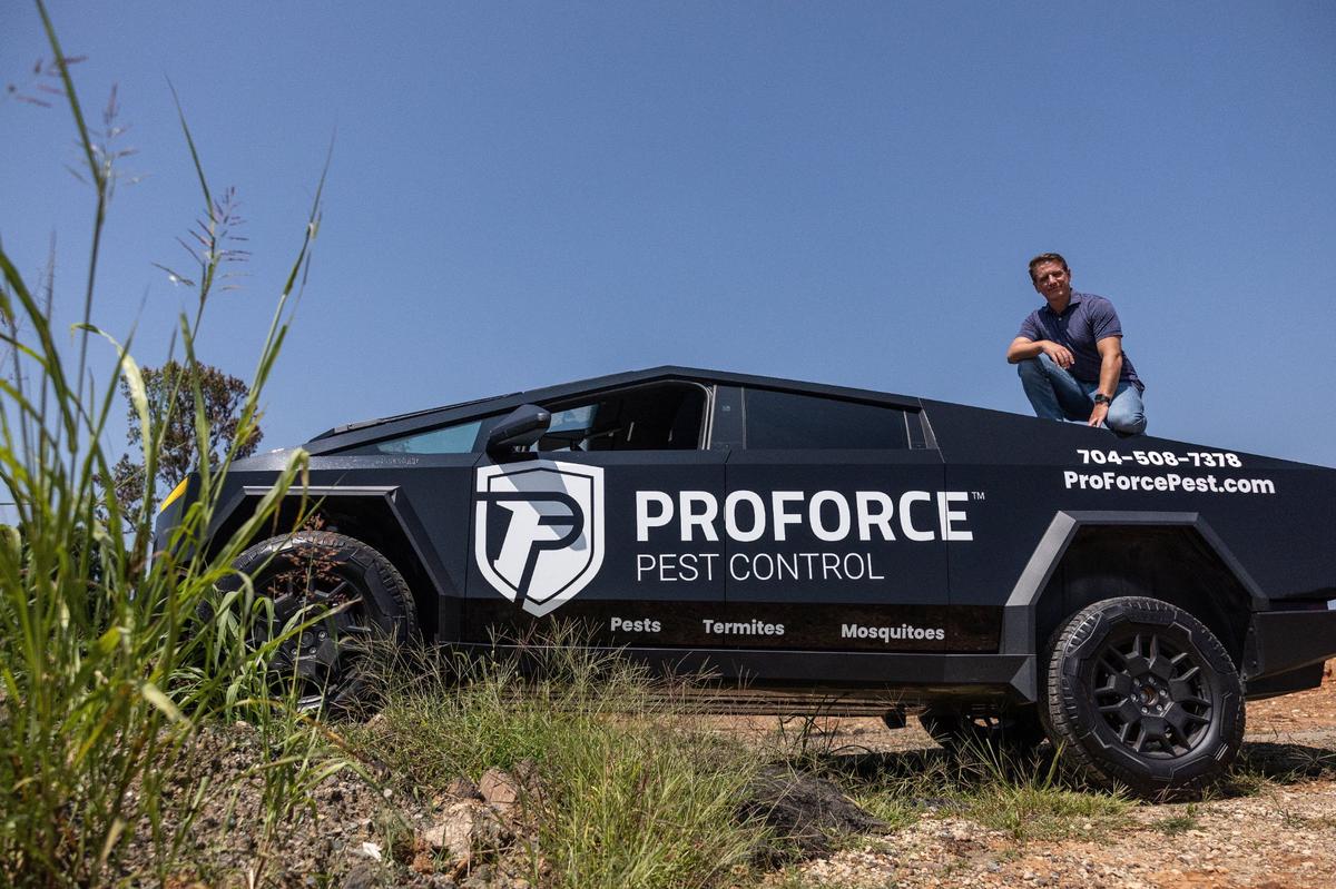 Spenser Morgan sits on his Tesla Cybertruck. The Charlotte business owner uses the vehicle to advertise ProForce Pest Control.