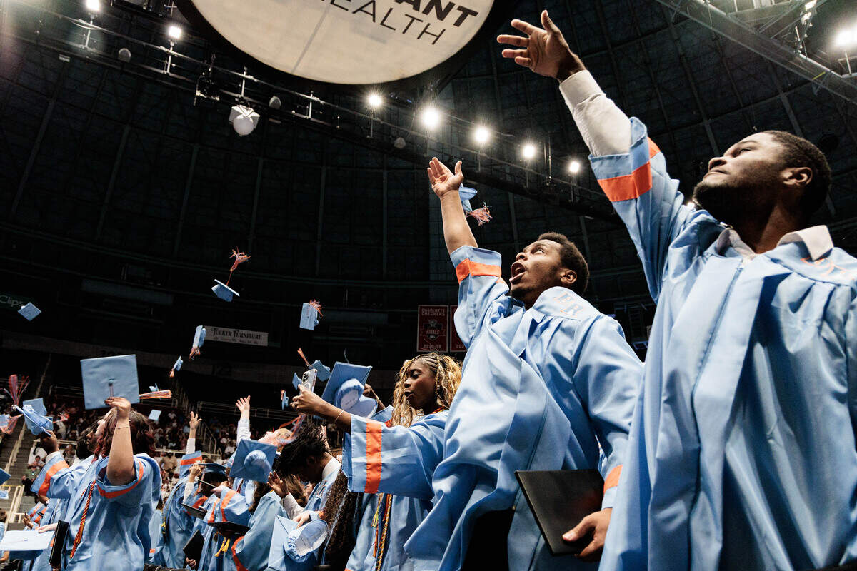 Newly graduated Ty’Barious Young (right) and Messiah Weatherford throw their caps into the air at the end of the Ballantyne Ride High School graduation at the Bojangles Coliseum on Saturday, June 13, 2026.