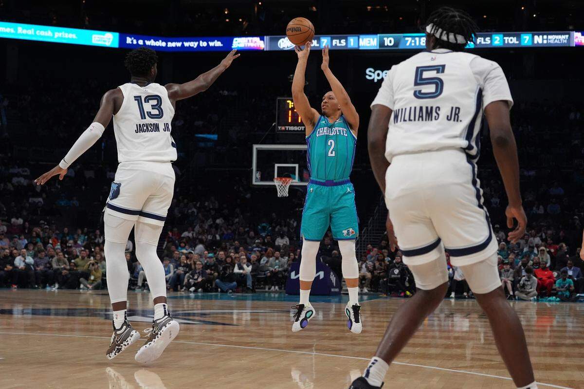 Feb 10, 2024; Charlotte, North Carolina, USA; Charlotte Hornets guard Grant Williams (22) shoots over Memphis Grizzlies forward Jaren Jackson Jr. (13) during the first quarter at Spectrum Center.
