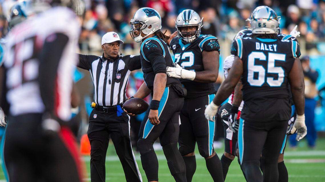 Panthers quarterback Cam Newton, center, is comforted by teammate Taylor Moton, second from right, after being sacked during the game against the Falcons at Bank of America Stadium on Sunday, December 12, 2021 in Charlotte, NC.