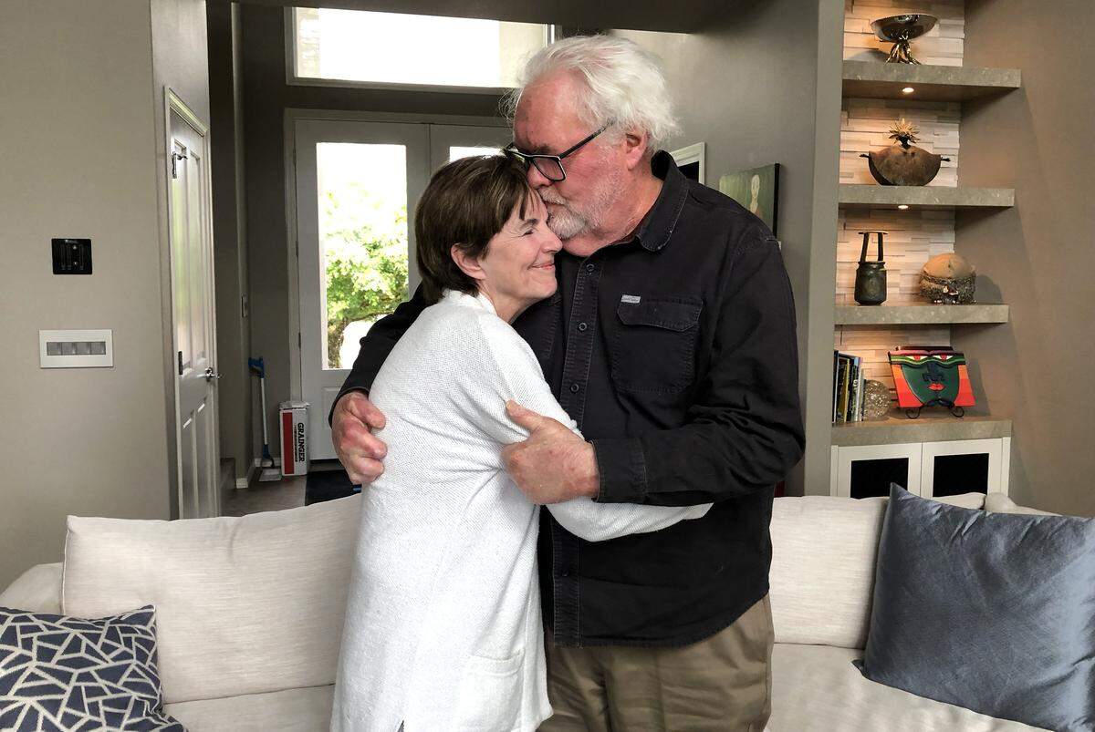 Eastern Flight 212 passenger Richard Arnold, right, kisses his wife Catherine at their home in Camas, Washington, on Sunday, April 28, 2024. Arnold suffered severe burns all over his body and had his hands permanently disfigured in the crash of Eastern Flight 212.