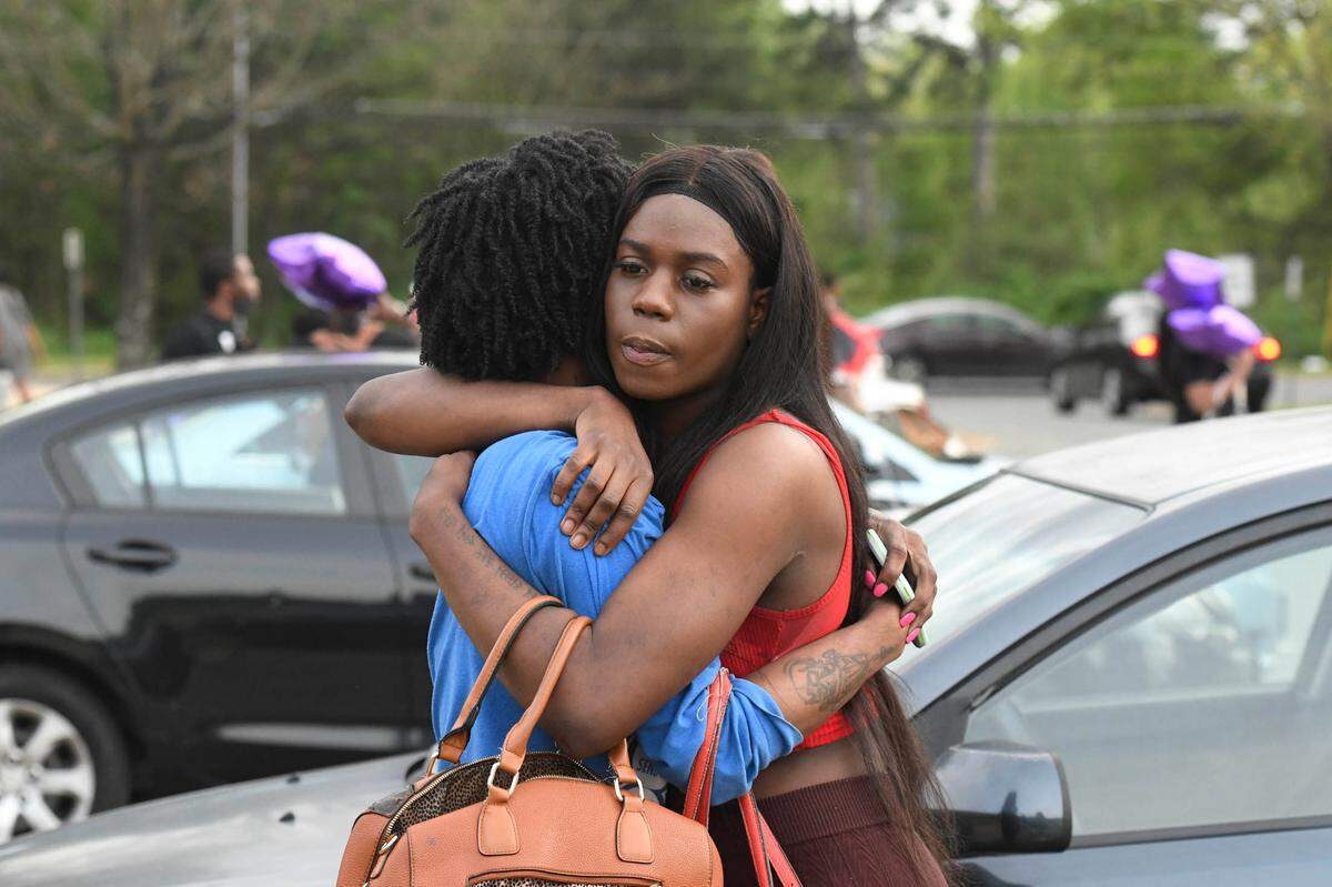 Mia Camps giver a hug to a friend prior to a memorial for Jaida Peterson at Tuckaseegee Park on April 9, 2021. Peterson was a transgender woman in Charlotte who was found dead in a hotel room on Easter Sunday.