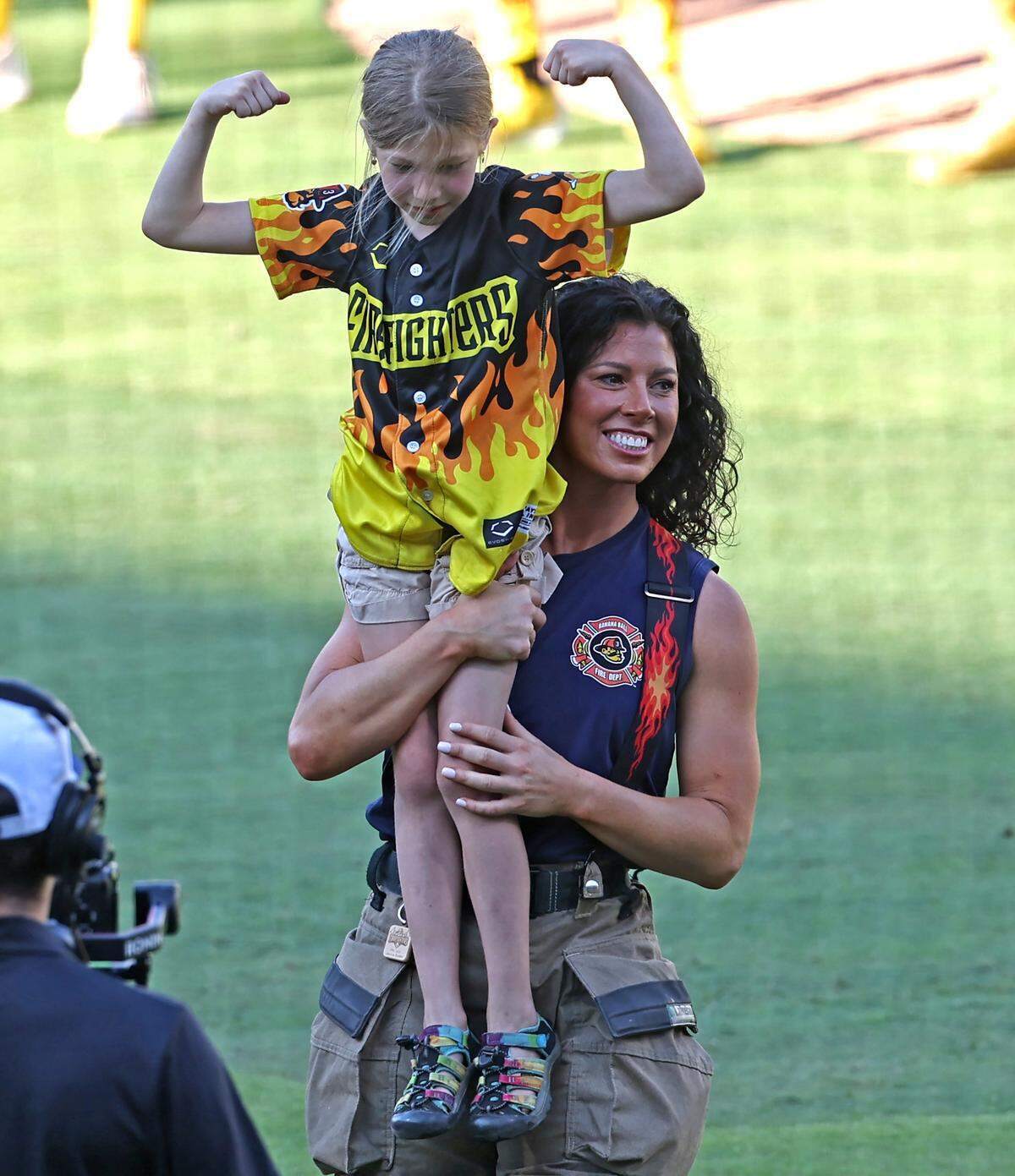 A young fan is lifted into the air after defeating members of the Firefighters team during a tug-o-war competition at Truist Field in Charlotte, NC on Thursday, June 4, 2026. Banana Ball action returned to the Queen City with the Texas Tailgaters battling the Firefighters.