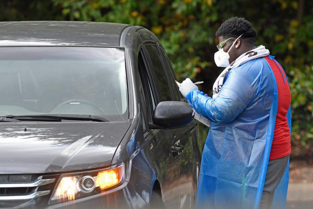 A healthcares professional works with a motorist at the Mecklenburg County Health Department’s Northwest Health Department location during drive-up testing for COVID-19 on Friday, October 23, 2020. The county tested at least 127 people for COVID-19 Thursday related to United Church of Christ outbreak.