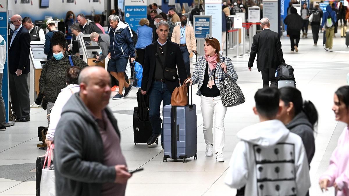 Travelers wearing masks and not walk through Charlotte Douglas International Airport on Tuesday, April 19, 2022.