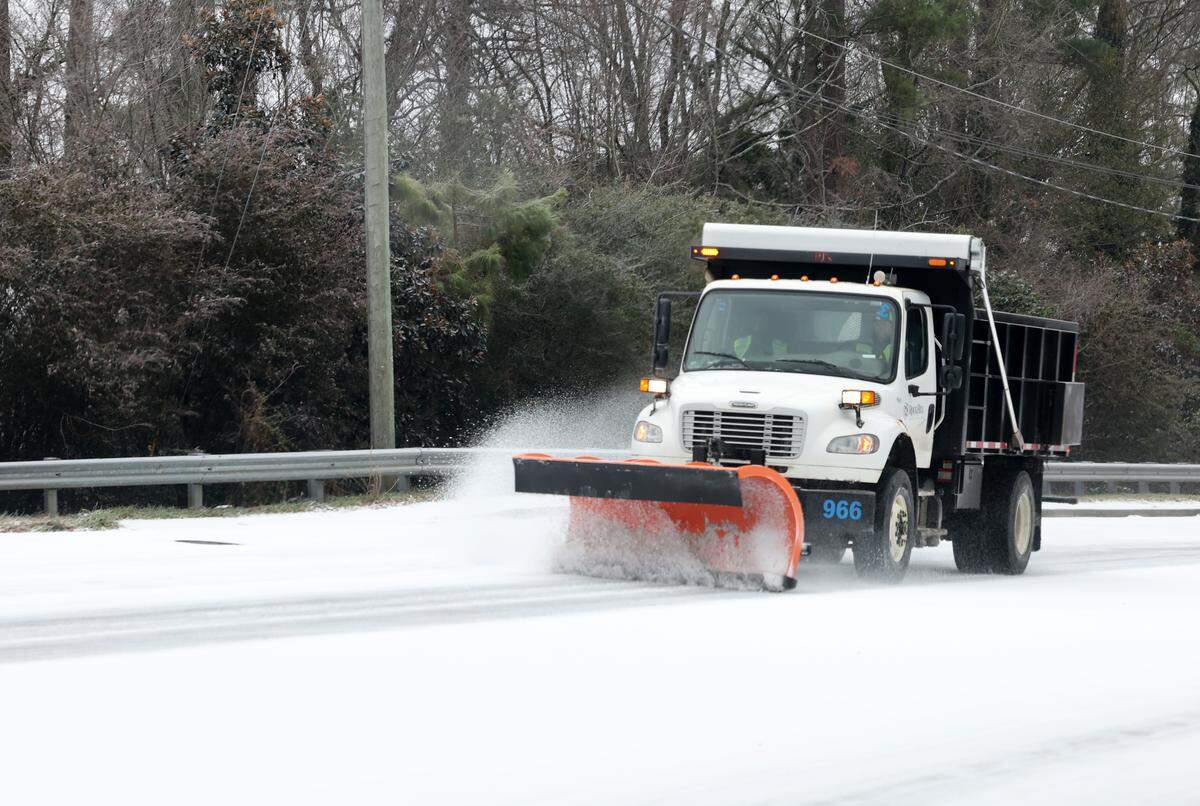 A plow scrapes India Hook Road in Rock Hill on Sunday.