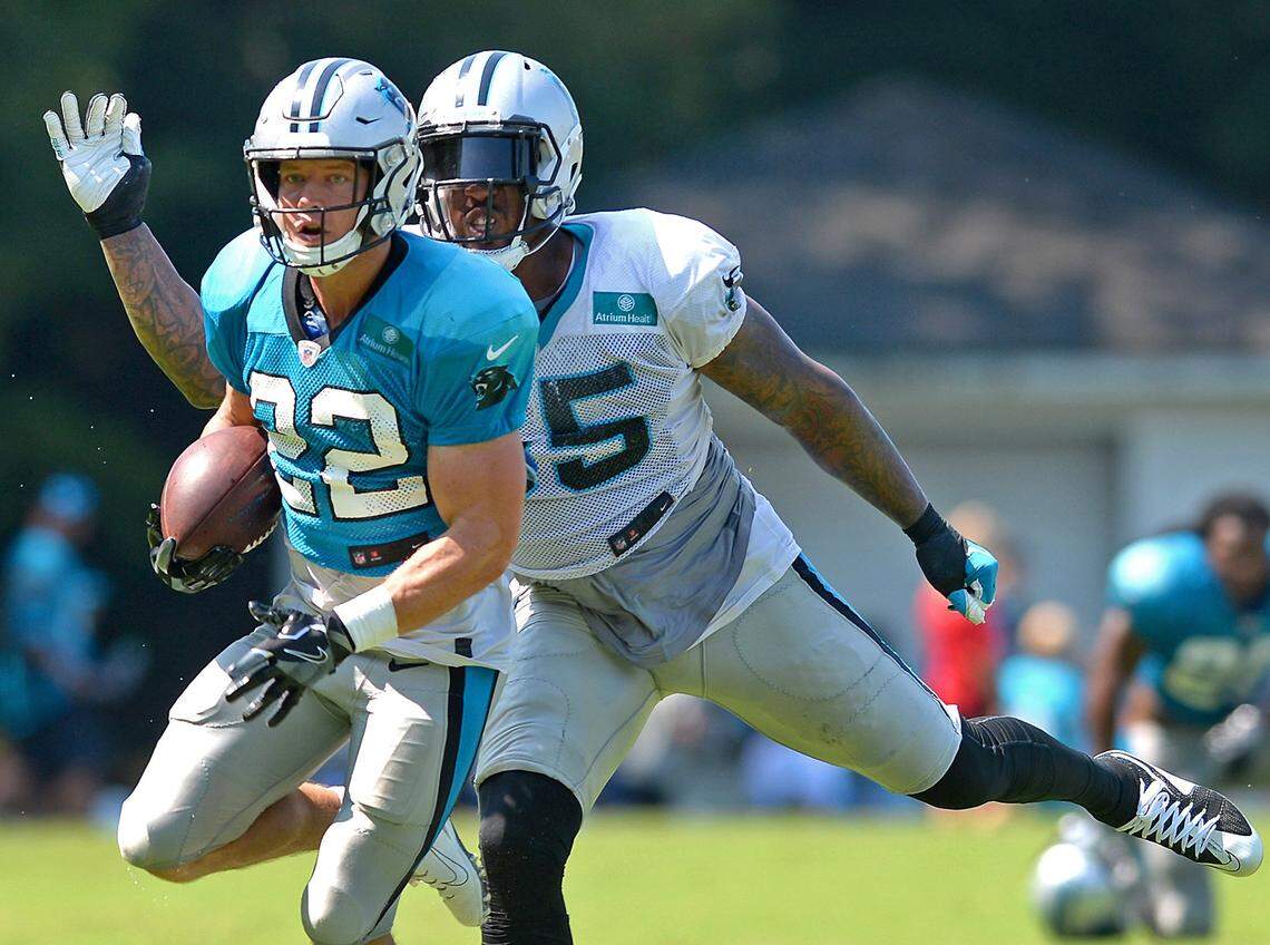 Carolina Panthers linebacker/defensive end Bruce Irvin, right, prepares to knock the ball away from running back Christian McCaffrey, left, during practice on Monday, July 29, 2019 at Wofford College in Spartanburg, SC.