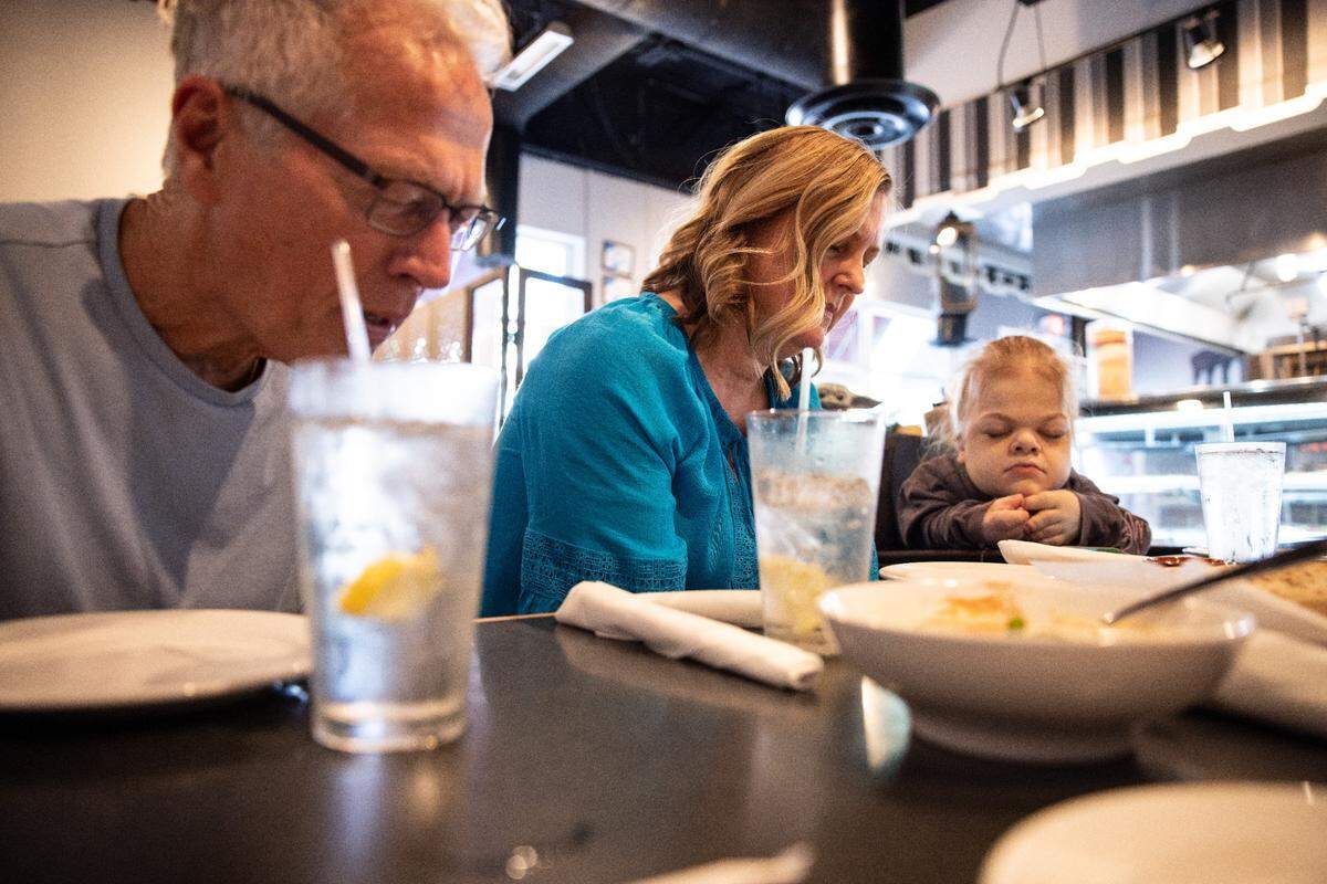 Jim, Lisa and Abby say grace before eating lunch at Kabob-Je’s restaurant in Matthews last month.
