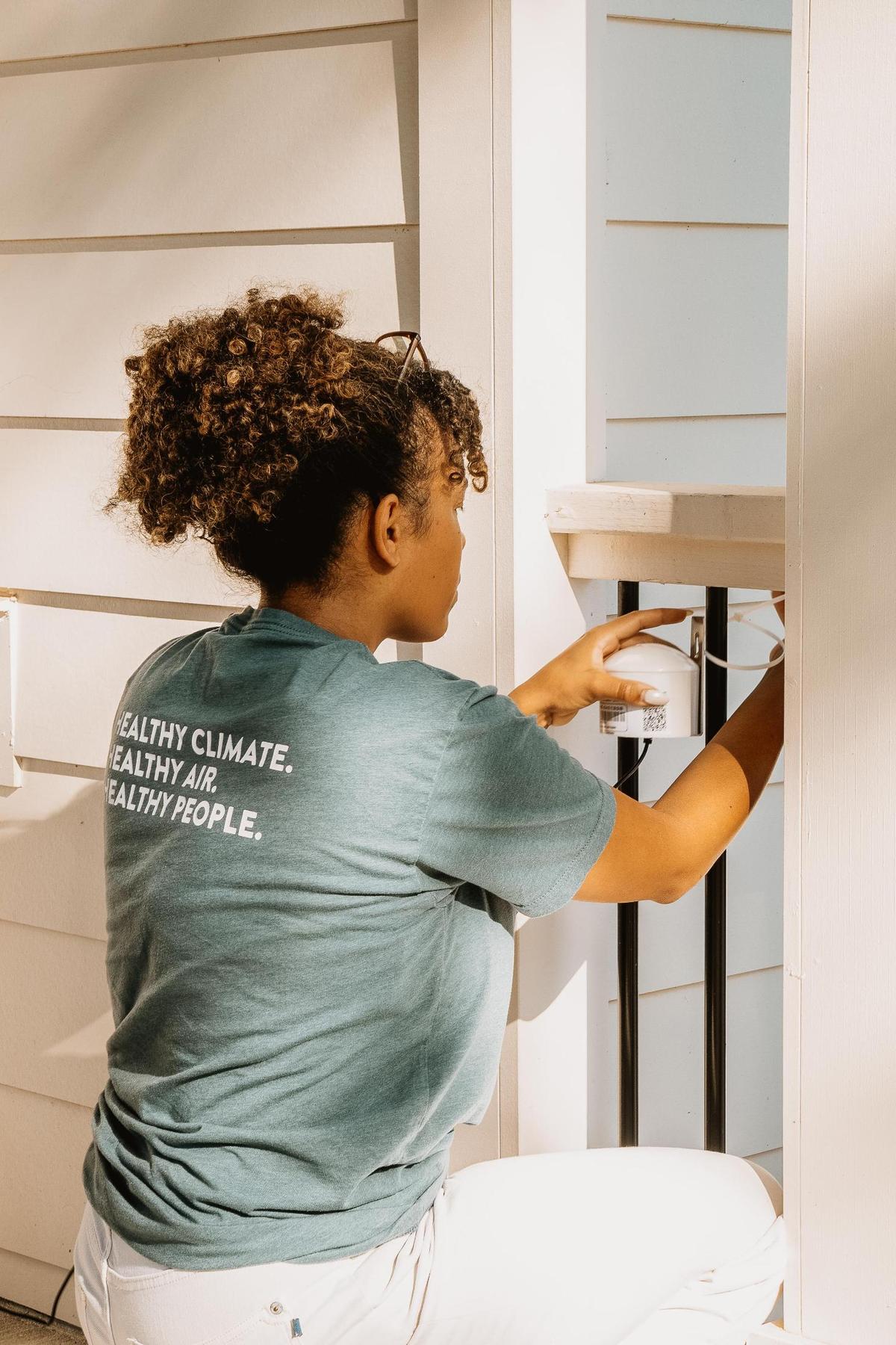 Daisha Wall, community science manager for CleanAIRE NC, installs at-home air monitors to review real-time air quality data. With funding cuts coming from the Trump Administration, she is concerned about the impact that will have on residents in north Mecklenburg County.