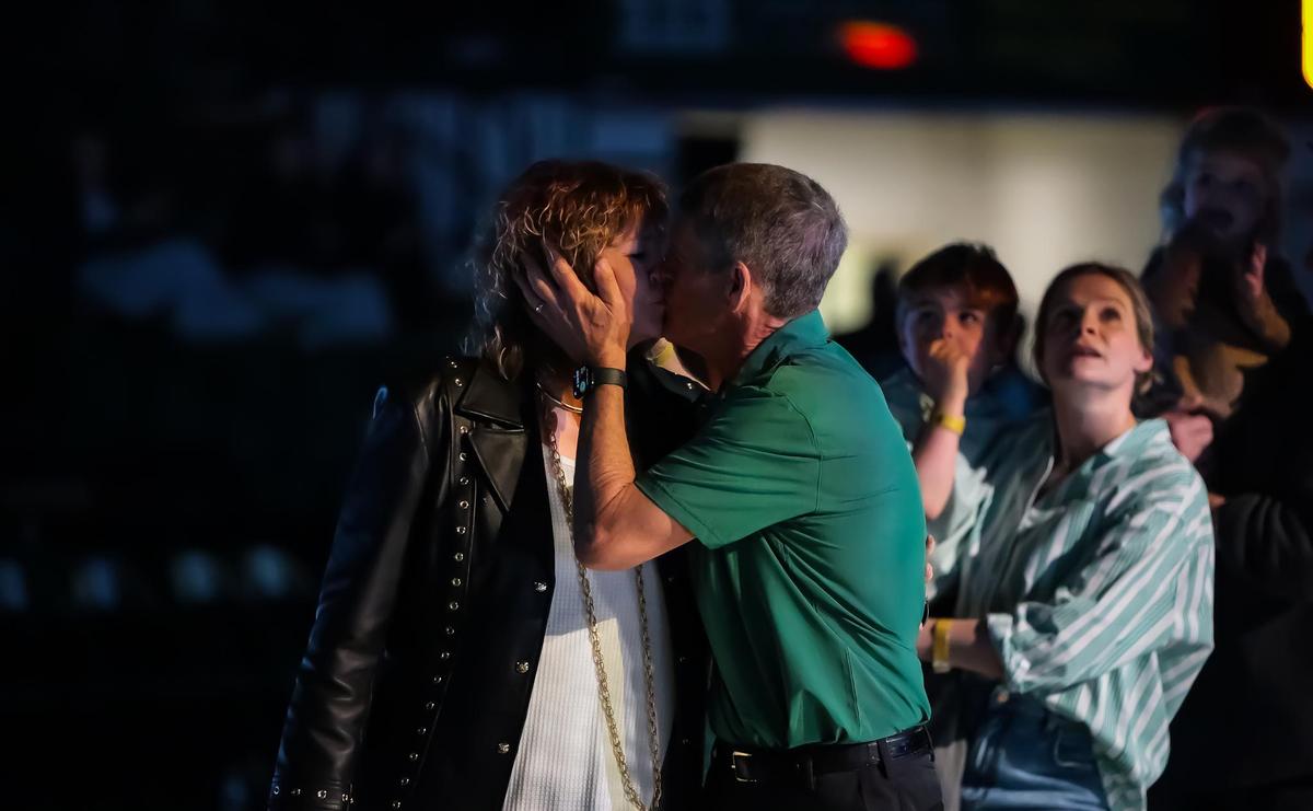 Bobby Lutz kisses his wife at mid court while being honored at halftime at the Charlotte 49ers-Rice men’s basketball game on Saturday, Feb. 8, in Charlotte, NC.
