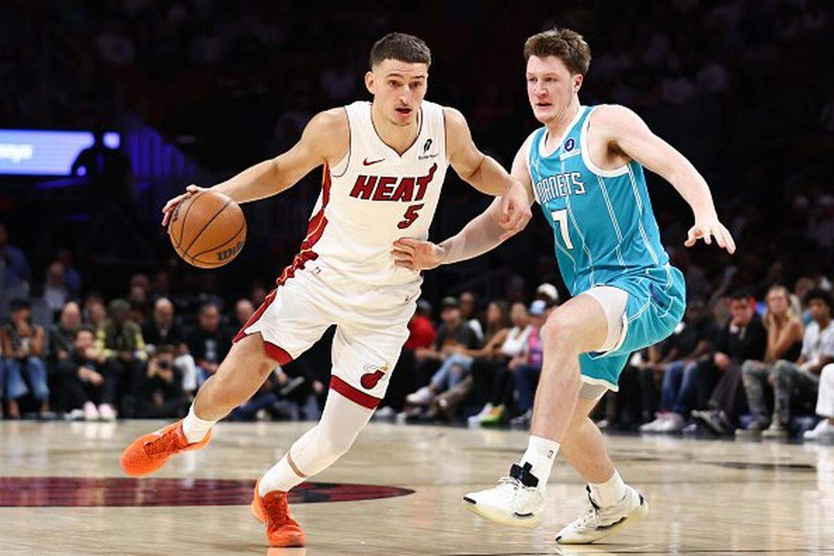 Nikola Jovic #5 of the Miami Heat handles the ball against Kon Knueppel #7 of the Charlotte Hornets during the second quarter of the game at Kaseya Center on October 28, 2025 in Miami, Florida.