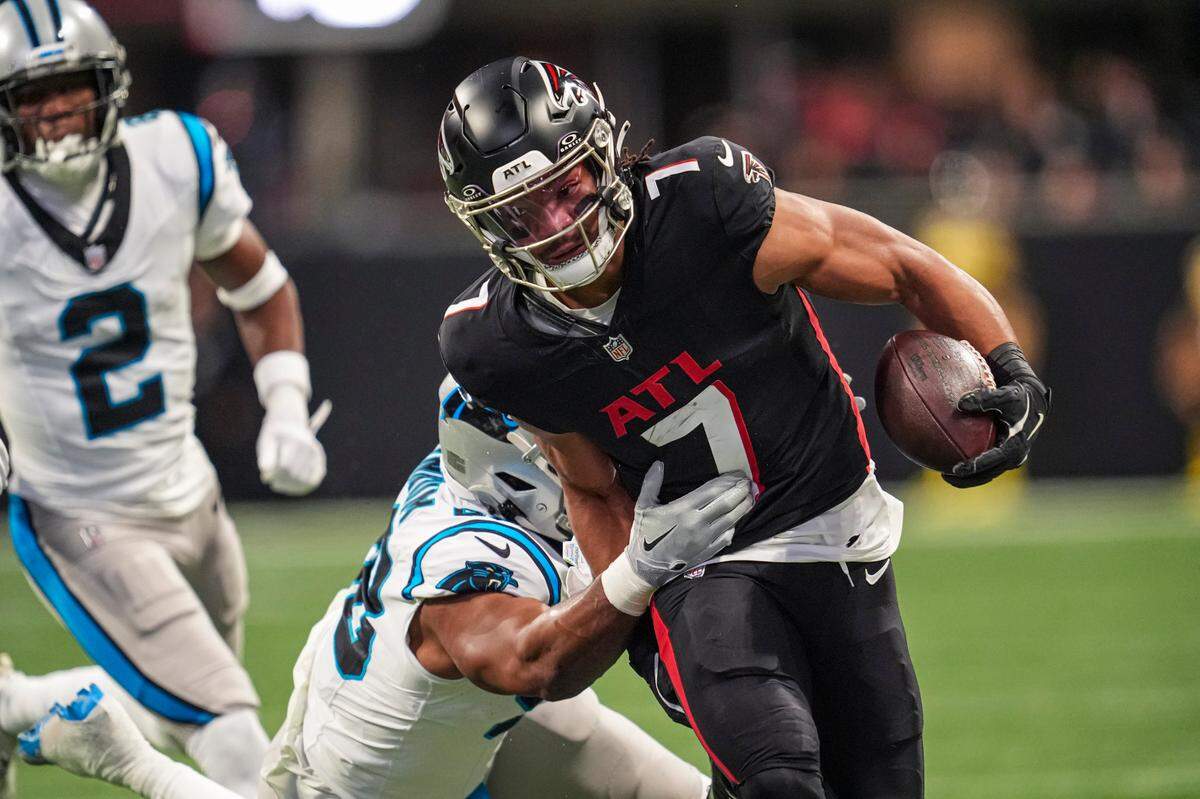 Atlanta Falcons running back Bijan Robinson (7) runs against Carolina Panthers linebacker D.J. Wonnum (98) during Sunday’s first quarter at Mercedes-Benz Stadium. 
