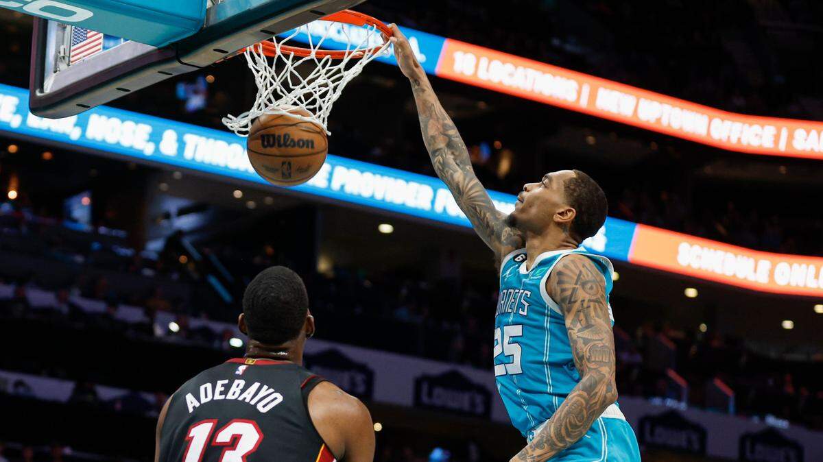 Charlotte Hornets forward P.J. Washington (25) dunks as Miami Heat center Bam Adebayo (13) looks on during the first half of an NBA basketball game in Charlotte, N.C., Sunday, Jan. 29, 2023. (AP Photo/Nell Redmond)
