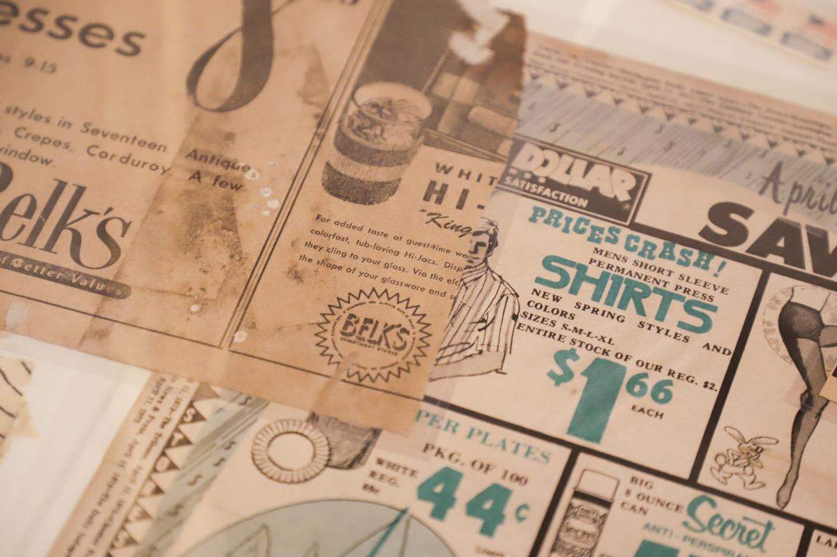 Advertisements from 1973, part of the surviving artifacts from the Mooresville time capsule sit on display at the Mooresville public library.