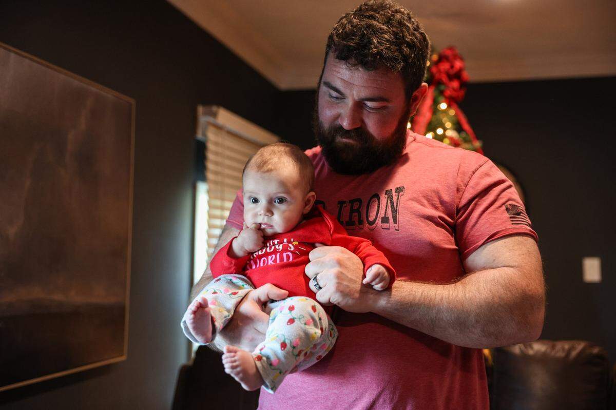 Dillon Sutton holds his four-month-old daughter, Zoie, at their home in Lincolnton, NC on Friday, December 6, 2024. Earlier this year Sutton faced a life-threatening heart failure, and in July, he underwent a heart transplant at Atrium Heart Sanger Heart & Vascular Institute. One week after surgery, he was home to welcome their first child.