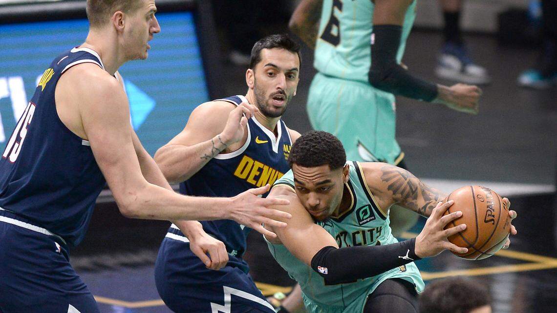 Charlotte Hornets forward PJ Washington, right, drives into the lane against the Denver Nuggets defense during first quarter action at Spectrum Center in Charlotte, NC on Tuesday, May 11, 2021.