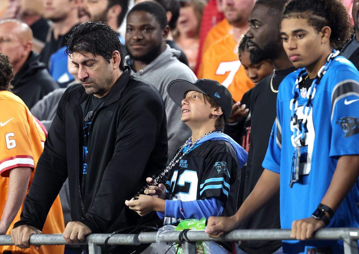 Dejected Carolina Panthers fans stand along the railing at Raymond James Stadium as the team battled the Tampa Bay Buccaneers on Saturday, January 3, 2026. The Buccaneers defeated the Panthers 16-14.