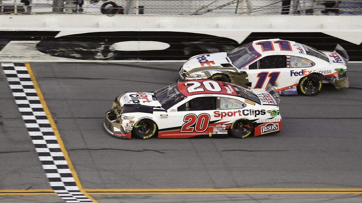 Erik Jones (20) heads to the finish line to win the NASCAR Busch Clash auto race at Daytona International Speedway, Sunday, Feb. 9, 2020, in Daytona Beach, Fla. Denny Hamlin (11), who was a lap down, helped Jones with a push in Turn 4. (AP Photo/John Raoux)