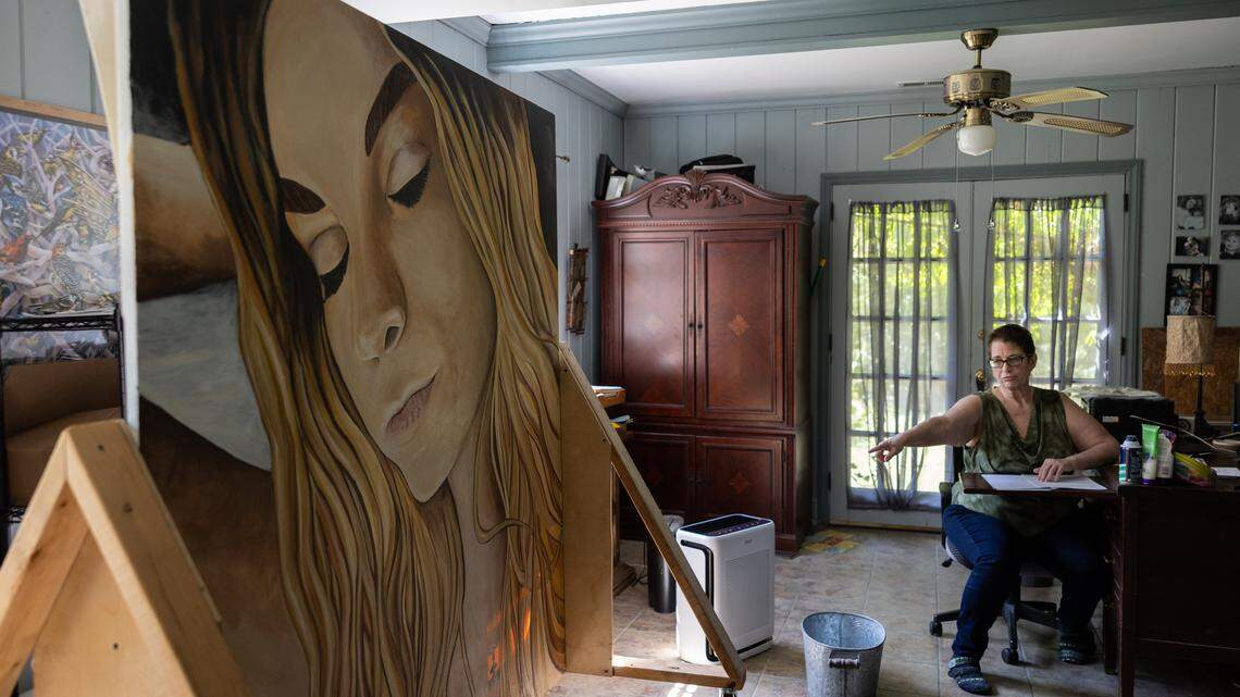 Mia Alderman points to a cross backlit with sunlight on a portrait painted of her granddaughter, Mary Collins, in Charlotte, N.C., on Wednesday, September 24, 2025. Mary Collins was murdered in 2020. Her grandmother, Mia Alderman, has been on a years-long campaign to seek justice for her.