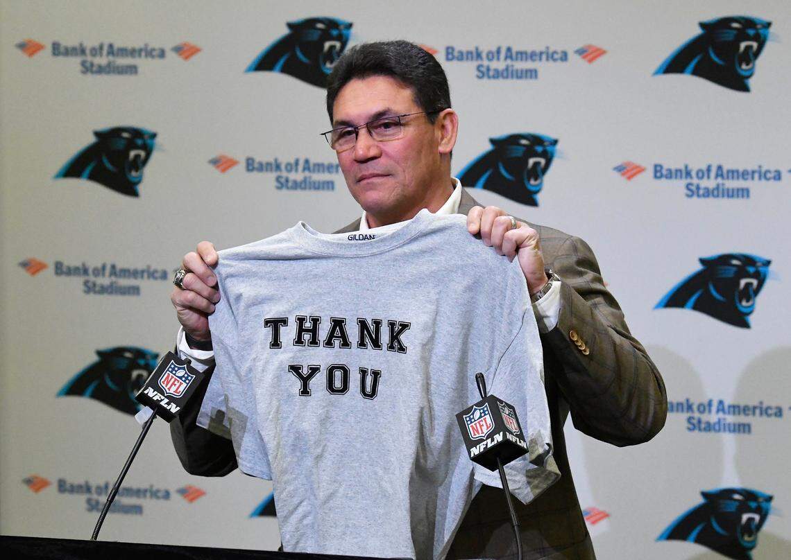 Former Carolina Panthers head coach Ron Rivera holds up a T-shirt at the end of his farewell press conference at Bank of America Stadium on Dec. 4, 2019. Rivera, the winningest coach in Carolina history, was fired by Tepper with four games left in the 2019 season.