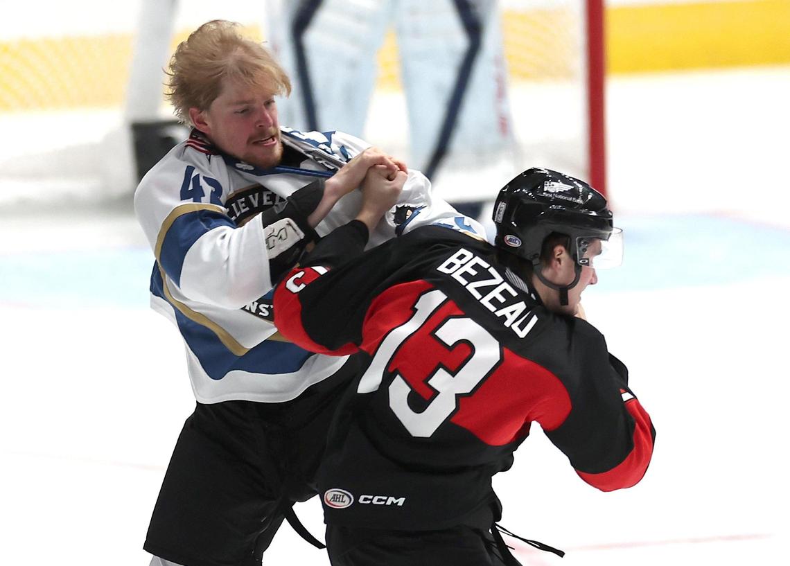 Cleveland Monsters Cameron Butler, left and Charlotte Checkers Riley Bezeau, right, fight during action at Bojangles Coliseum in Charlotte, NC on Friday, October 18, 2024.