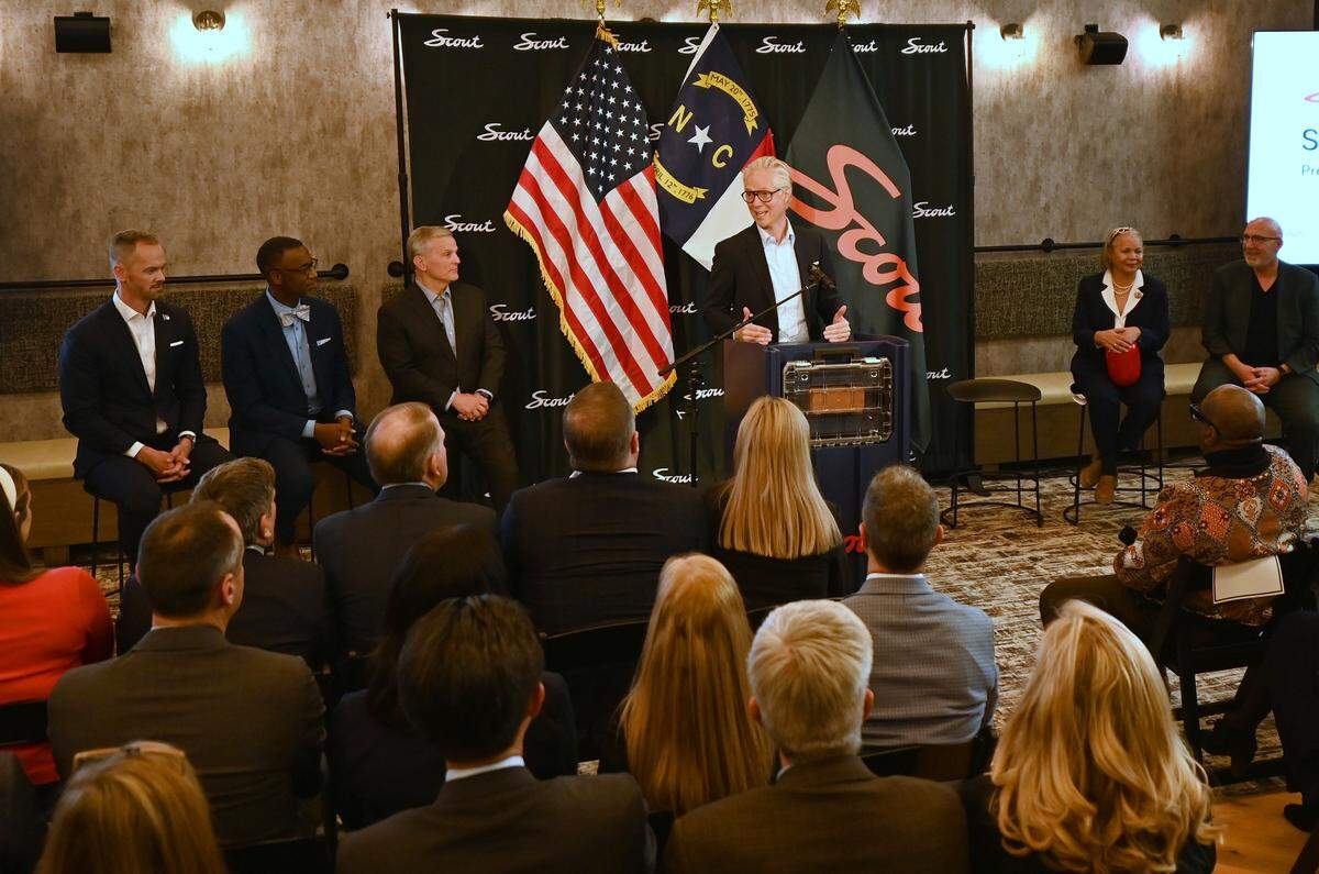 Scout Motors President Scott Keogh addresses the audience gathered at 1710 Commonwealth Ave. with news that the company is making Charlotte its new corporate headquarters on Tuesday. He is flanked by Gov. Josh Stein and Mayor Vi Lyles.