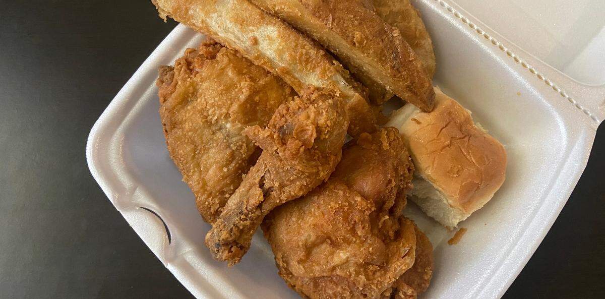 The Quik Shoppe Shell Station fried chicken combo, with two thighs and a leg plus a side of fried potatoes and a dinner roll.