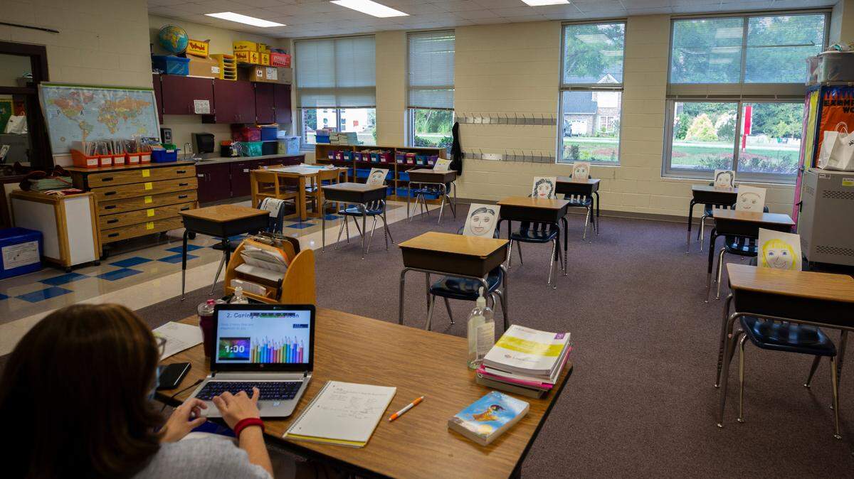 Drawings of faces fill the desks of Donna Golden’s 5th grade classroom as she teaches virtually on the first day of school at Paw Creek Elementary School, Monday August 17, 2020.