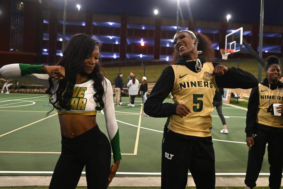 Charlotte 49ers women’s basketball player Nia Young, right, works on her dance moves with Five Star cheerleader Zionah Davis, left, during fan fest at the University Recreation Center on the campus of UNC Charlotte on Thursday, October 17, 2024.