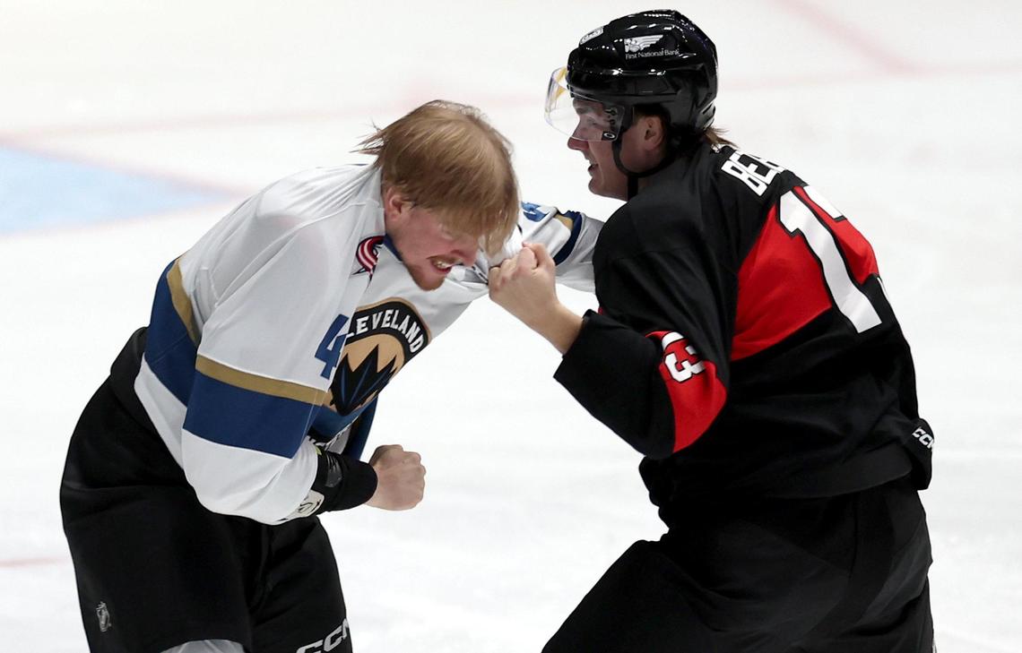 Cleveland Monsters Cameron Butler, left, takes a punch to the face during a fight with Charlotte Checkers Riley Bezeau, right, at Bojangles Coliseum in Charlotte, NC on Friday, October 18, 2024.
