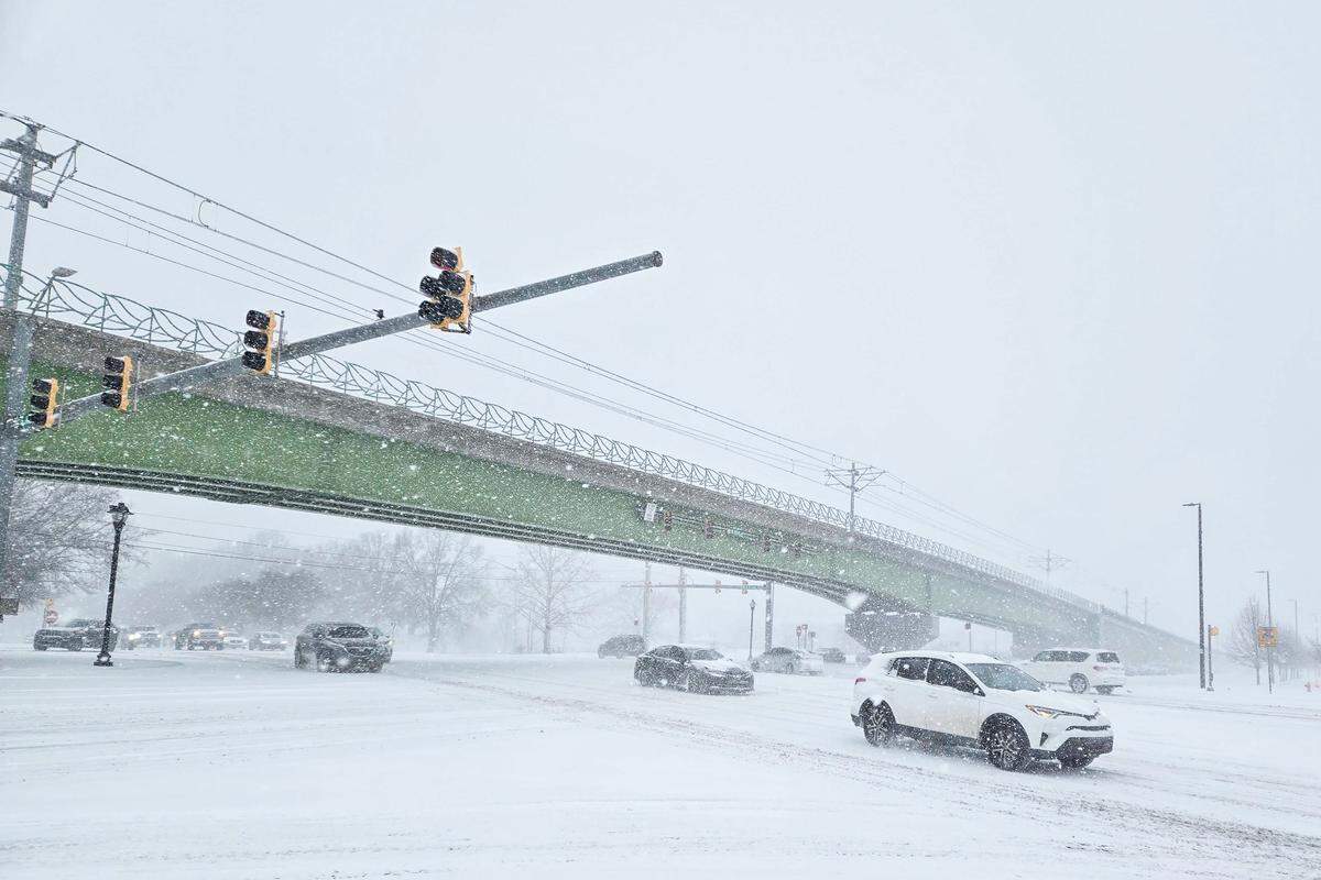 Cars drive down a snow-covered street at the intersection of W.T. Harris Blvd. and North Tryon Street on Saturday, January 31, 2026.