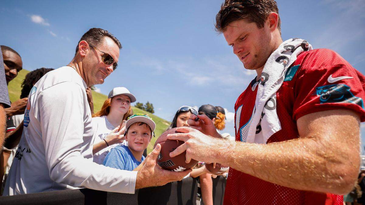 Carolina Panthers quarterback Sam Darnold (14) signs autographs for fans after the teams training camp practice at Wofford College in Spartanburg, S.C., Thursday, July 28, 2022.