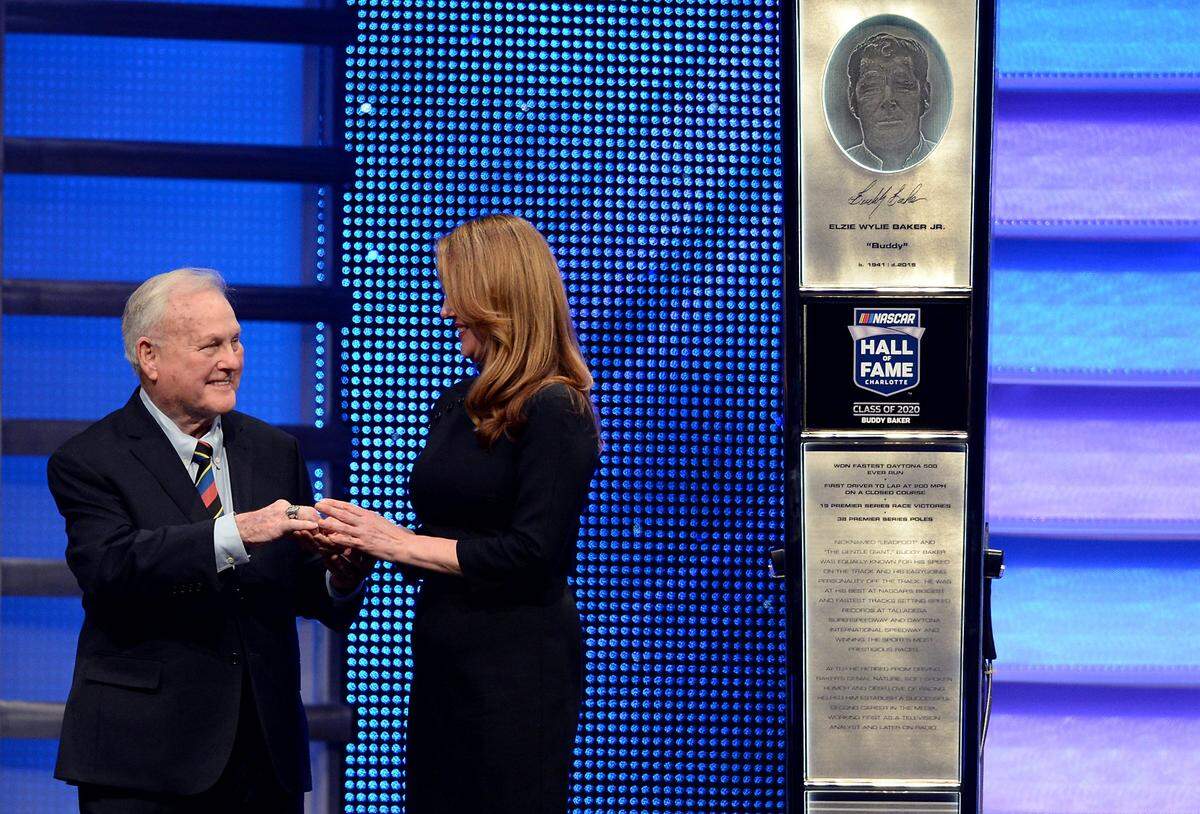 Former Charlotte Motor Speedway president Humpy Wheeler presents Susie Baker with NASCAR Hall of Fame member Buddy Baker's ring during his NASCAR Hall of Fame induction ceremony in 2020.  Baker was inducted into the Hall of Fame with Joe Gibbs, Tony Stewart, Waddell Wilson and Bobby Labonte. Susie Baker is Buddy Baker's sister.