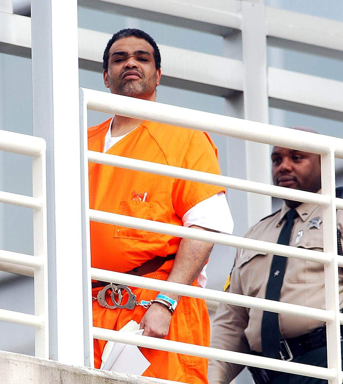 Van Brett Watkins, left, is escorted by a Mecklenburg County Sheriff deputy into the Mecklenburg County Courthouse Monday, Oct. 13, 2003, in Charlotte, N.C. Former Carolina Panther Rae Carruth and three men including Watkins who conspired to murder Carruth’s pregnant girlfriend should pay almost $5.8 million in damages to her estate, a lawyer for the girlfriend’s mother told a judge Monday. The request by attorney Billie Ellerbe came during a hearing on damages in Saundra Adams’ wrongful death lawsuitagainst Carruth, Watkins, Michael Kennedy and Stanley Abraham. The four men were convicted in early 2001 of conspiring in the Nov. 16, 1999, ambush shooting of Adam’s daughter Cherica. (AP Photo/Charlotte Observer, David T. Foster III)