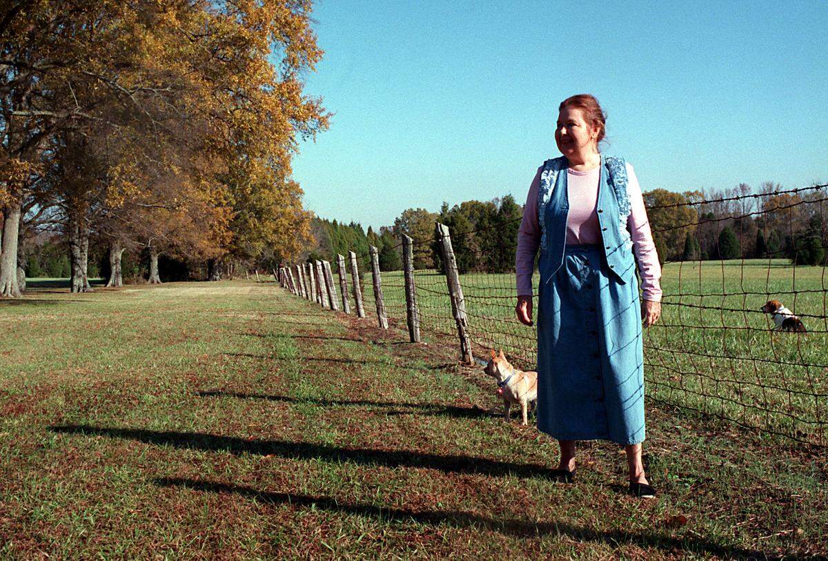 In this August 2005 Charlotte Observer file photo, Ruth Threatt walks her southern Mecklenburg County land with her dog Pound Cake.