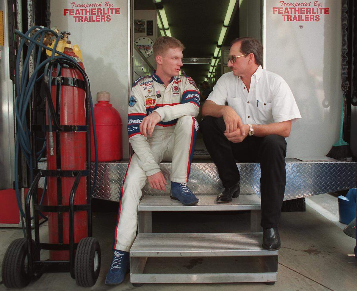 Dale Earnhardt Jr., left, and Dale Earnhardt Sr., sit on the back of the latter's transporter in 1998 discussing Earnhardt Jr.'s preparation for Carquest 300 Grand National qualifications.