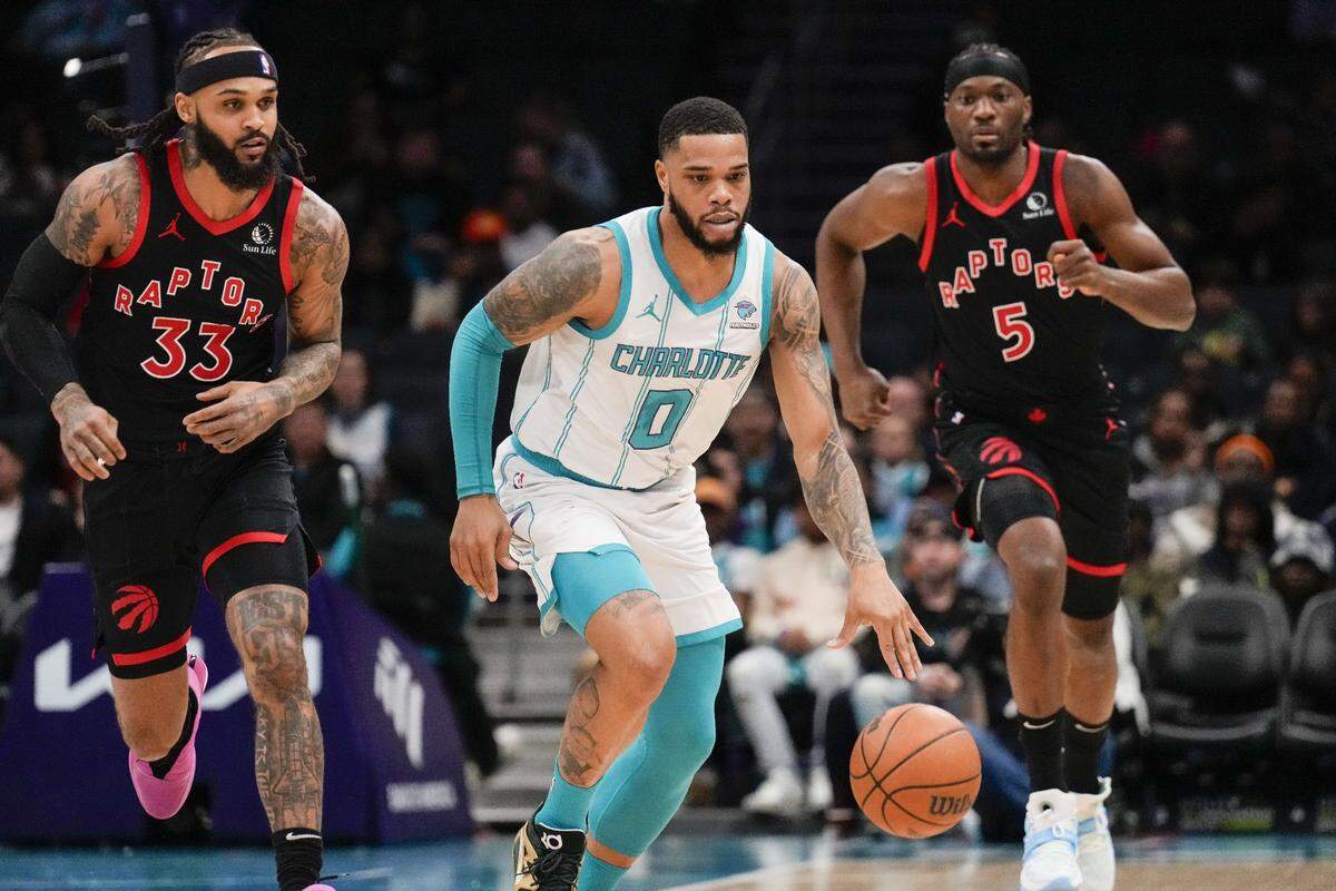 Charlotte Hornets forward Miles Bridges (0) dribbles ahead of Toronto Raptors guard Gary Trent Jr. (33) and forward Precious Achiuwa (5) during the first quarter at the Spectrum Center.