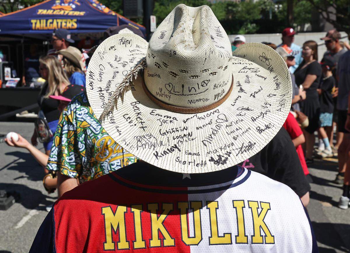 Texas Tailgaters manager Joe Mikulik's cowboy hat is adorned with the signatures of young fans outside Truist Field in Charlotte, NC on Thursday, June 4, 2026. Banana Ball action returned to the Queen City with the Texas Tailgaters battling the Firefighters.