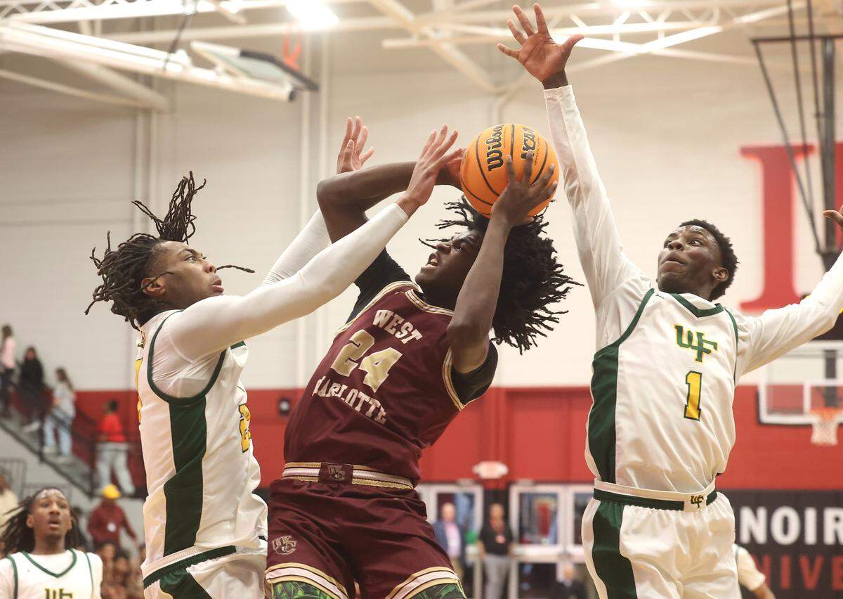 West Charlotte’s Kaharri Coleman, center, fights his way to the basket for a shot against West Forsyth defenders Camron Kerns, left and Kamauri Manuel, right, during the NCHSAA 8A boys' regional championship game on Wednesday, March 4, 2026 at Lenoir-Rhyne University in Hickory, NC. West Charlotte defeated West Forsyth 74-70.